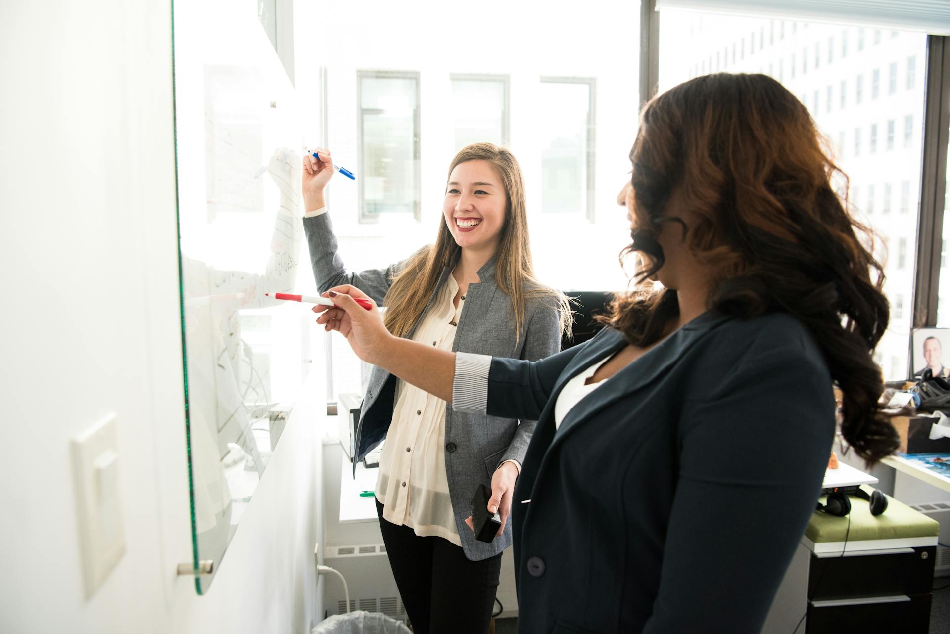 Collega's schrijven op kantoor op whiteboard