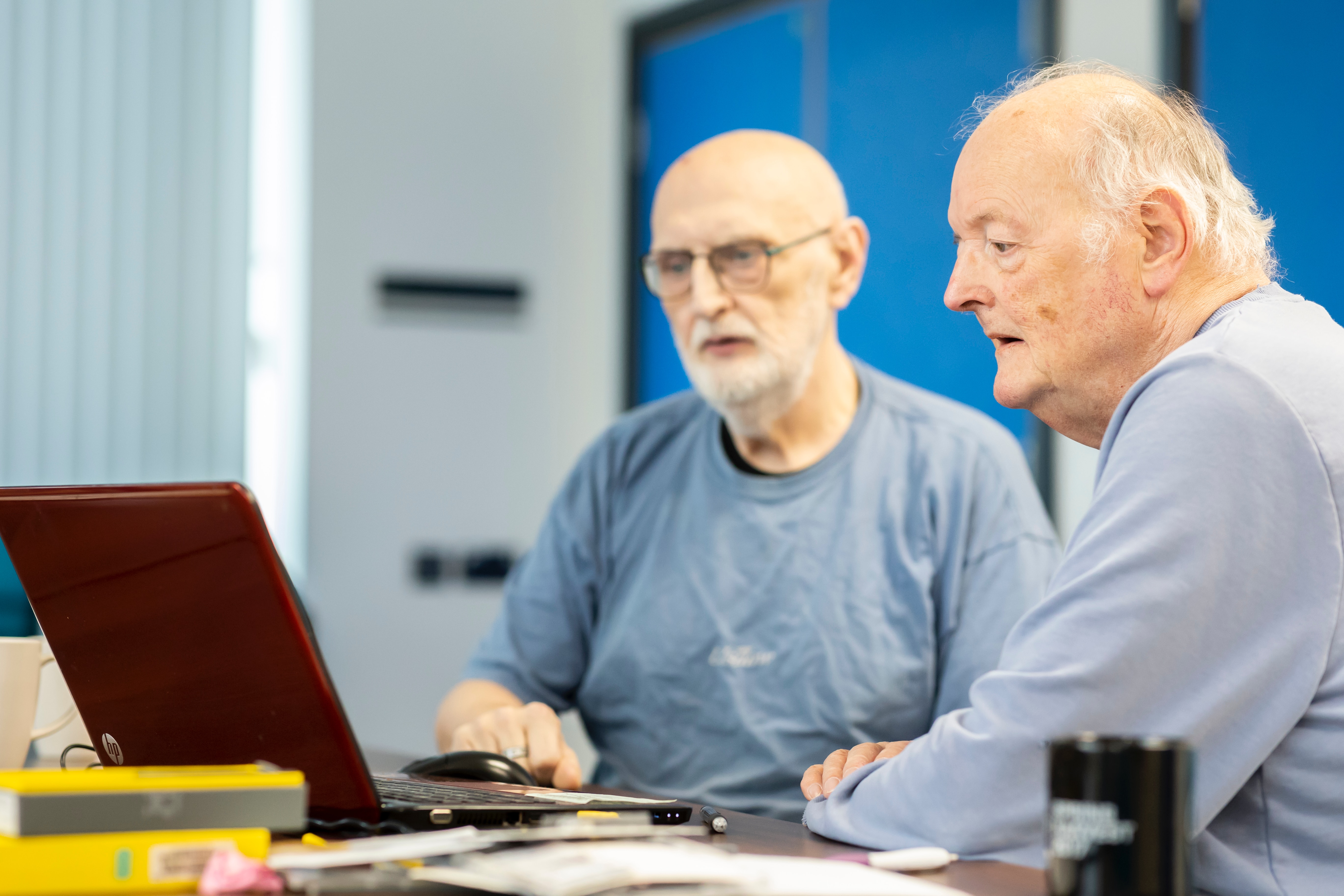 Twee mannen kijken naar een computerscherm.