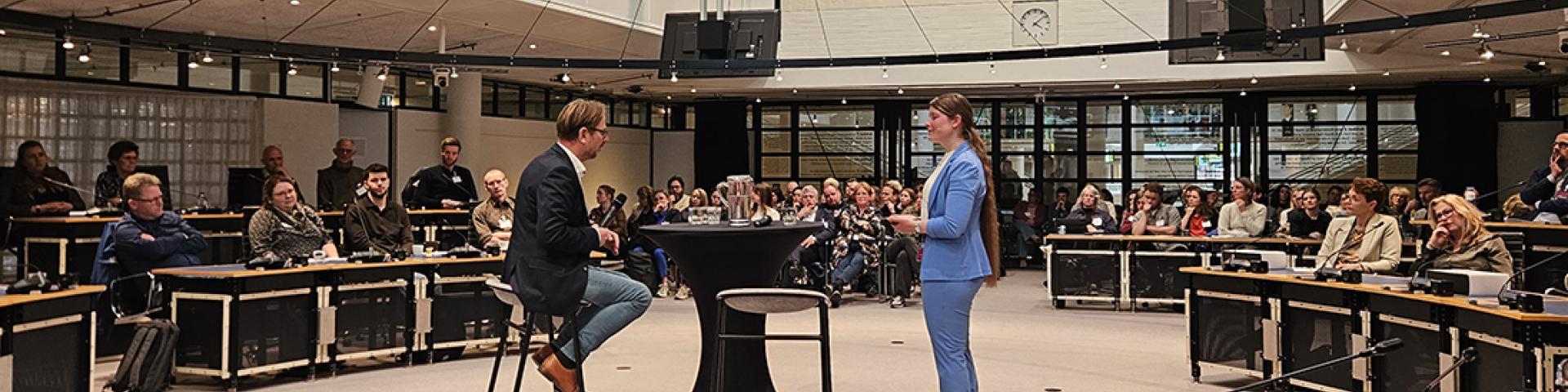 Larissa interviewt Frank van de Laar tijdens de roadshow in de raadzaal in Apeldoorn