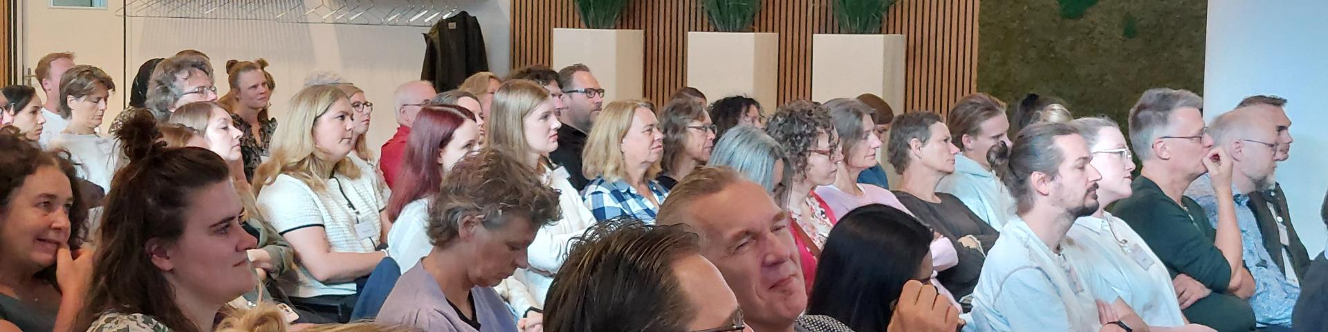 Publiek in de Balkonzaal van SVB in Utrecht luistert aandachtig tijdens de roadshow